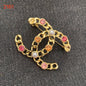 Studded letter tassel brooch